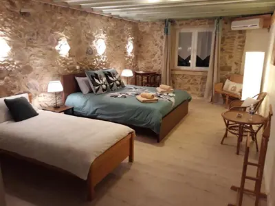 a bedroom with two beds and a table and chairs at Chambres d'hôtes Les Gragniotes in Tournissan
