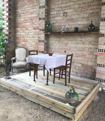 a table and chairs sitting on a wooden deck at Ma caravane dans les collines in Villeneuve-la-Comptal