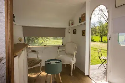 a room with two chairs and a table and a window at Ma caravane dans les collines in Villeneuve-la-Comptal