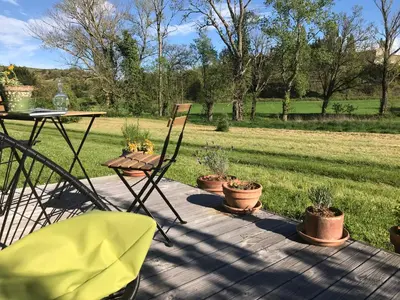 a patio with chairs and a table and potted plants at Ma caravane dans les collines in Villeneuve-la-Comptal