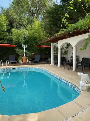 a swimming pool with a pergola next to a patio at Bed & Breakfast Le Beauséjour in Carcassonne