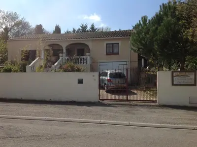 a house with a fence and a car in front of it at Bed & Breakfast Le Beauséjour in Carcassonne