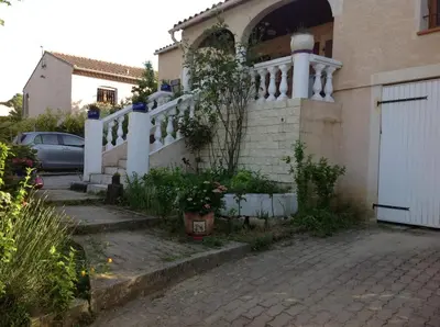 a house with a white railing and a driveway at Bed & Breakfast Le Beauséjour in Carcassonne