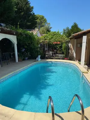 a large blue swimming pool in a yard at Bed & Breakfast Le Beauséjour in Carcassonne