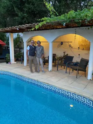 two people are standing next to a swimming pool at Bed & Breakfast Le Beauséjour in Carcassonne