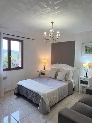 a bedroom with a large bed and a chandelier at Bed & Breakfast Le Beauséjour in Carcassonne