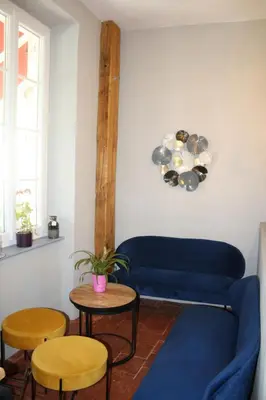 a living room with a blue couch and two tables at Le Therminus chambres d hôtes in Rennes-les-Bains
