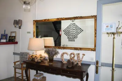 a mirror and a table with flowers on it at Le Therminus chambres d hôtes in Rennes-les-Bains