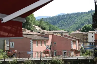 a view of a town with pink houses and trees at Le Therminus chambres d hôtes in Rennes-les-Bains