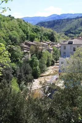 a view of a river with buildings and trees at Le Therminus chambres d hôtes in Rennes-les-Bains