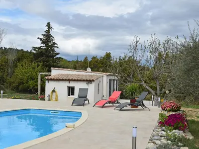 a small house with a swimming pool and chairs at Tranquil Villa with Pool in Lézignan-Corbières