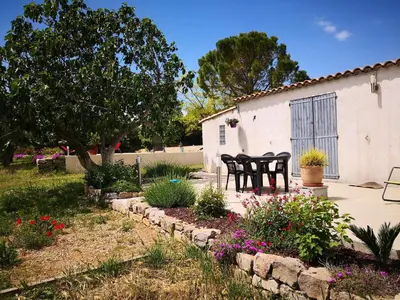 a patio with chairs and flowers in a yard at Tranquil Villa with Pool in Lézignan-Corbières
