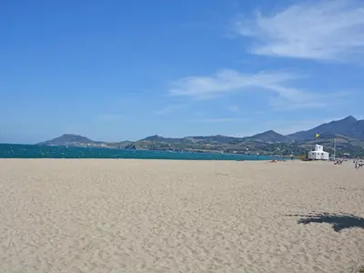 a sandy beach with a white lighthouse in the distance at Tranquil Villa with Pool in Lézignan-Corbières