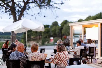 a table with a bottle of wine and a plate of food at Château Catherine de Montgolfier - B&B et Gites - Piscine - Domaine viticole bio avec dégustation in Narbonne