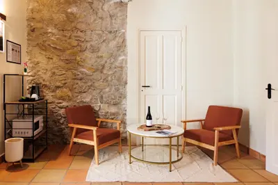 a building with an open door with people sitting inside at Château Catherine de Montgolfier - B&B et Gites - Piscine - Domaine viticole bio avec dégustation in Narbonne