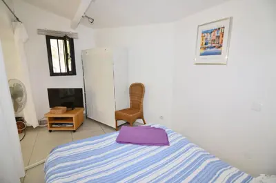 a bedroom with a bed with a purple bag on it at La petite Cigale in Cesseras