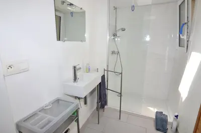 a white bathroom with a sink and a shower at La petite Cigale in Cesseras