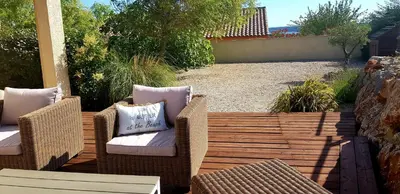 two wicker chairs and a table on a patio at La villa marquesa in Fitou