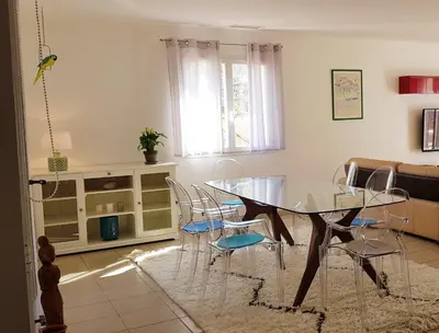 a dining room with a glass table and chairs at La villa marquesa in Fitou