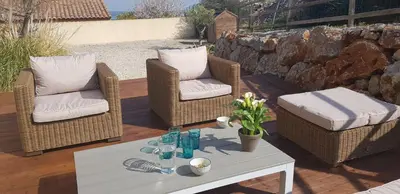 two wicker chairs and a table on a patio at La villa marquesa in Fitou