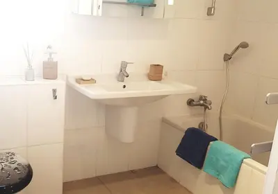 a white bathroom with a sink and a bath tub at La villa marquesa in Fitou