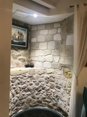 a stone wall with a picture on the wall at Chambre du Puits du Couvent in Narbonne