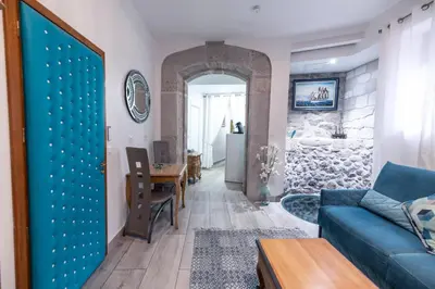 a living room with a blue couch and a table at Chambre du Puits du Couvent in Narbonne
