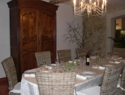 a dining room with a table with chairs and a chandelier at Chambres d'Hotes Domaine de la Capelle in Saint-Martin-Lalande