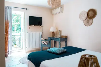 a bedroom with a bed and a desk and a television at Logis hôtel et restaurant La Bastide Cabezac in Bize-Minervois