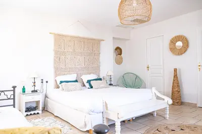 a white bedroom with a white bed and blue pillows at Logis hôtel et restaurant La Bastide Cabezac in Bize-Minervois