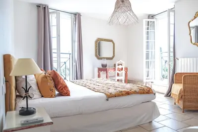 a bedroom with a bed and a table with a lamp at Logis hôtel et restaurant La Bastide Cabezac in Bize-Minervois