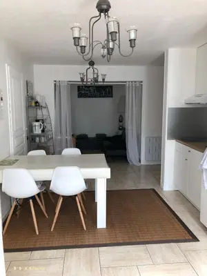 a dining room table with white chairs and a chandelier at VVA in Conques-sur-Orbiel