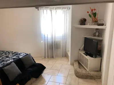 a bedroom with a bed and a tv and a window at VVA in Conques-sur-Orbiel