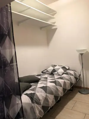 a bedroom with a bed with black and white sheets at VVA in Conques-sur-Orbiel