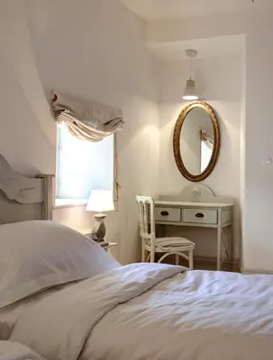 a bedroom with a bed and a desk with a mirror at Appartements du Vin in Caudiès-de-Fenouillèdes