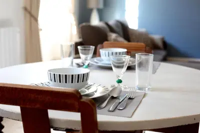 a table with plates and glasses and silverware on it at Appartements du Vin in Caudiès-de-Fenouillèdes