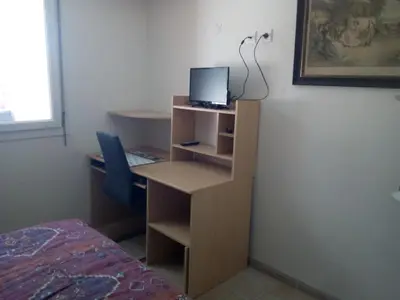 a room with a desk with a computer and a bed at Appartement en bord de mer in Port-la-Nouvelle