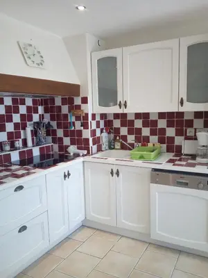 a kitchen with white cabinets and red and white tiles at Appartement en bord de mer in Port-la-Nouvelle