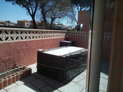 a bath tub sitting outside of a building at Appartement en bord de mer in Port-la-Nouvelle