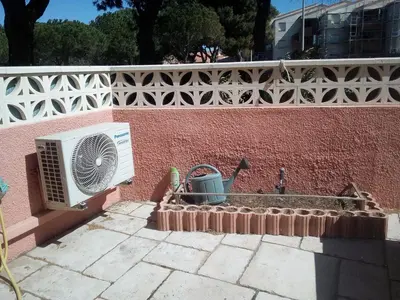 a fan sitting on the side of a brick wall at Appartement en bord de mer in Port-la-Nouvelle