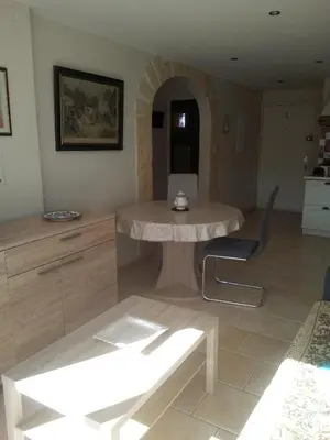 a living room with a table and a chair at Appartement en bord de mer in Port-la-Nouvelle
