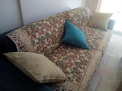 a couch with pillows on it in a living room at Appartement en bord de mer in Port-la-Nouvelle