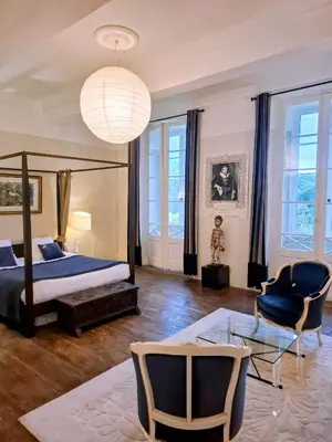 a bedroom with a bed and a table and chairs at B&B Château de Fajac la Selve in Pech-Luna