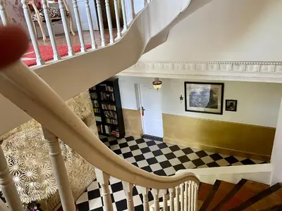 a staircase in a house with a checkerboard floor at B&B Château de Fajac la Selve in Pech-Luna
