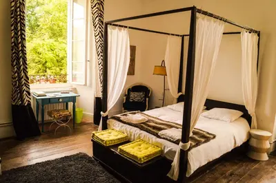 a bedroom with a canopy bed and a window at B&B Château de Fajac la Selve in Pech-Luna