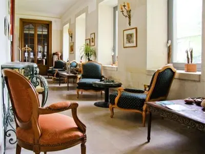 a living room with chairs and a table in a room at APOSTROPHE Chambres d'Hôtes in Montolieu