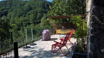 a patio with two red chairs and a table on a hill at Stunning view in Cathar country in Cailla