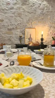 a table with a plate of food and two glasses of orange juice at LA COUR CARREE - chambres d'hôtes in Carcassonne