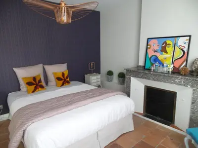 a bedroom with a bed and a fireplace at LA COUR CARREE - chambres d'hôtes in Carcassonne