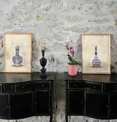a table with two pictures and two vases on it at LA COUR CARREE - chambres d'hôtes in Carcassonne